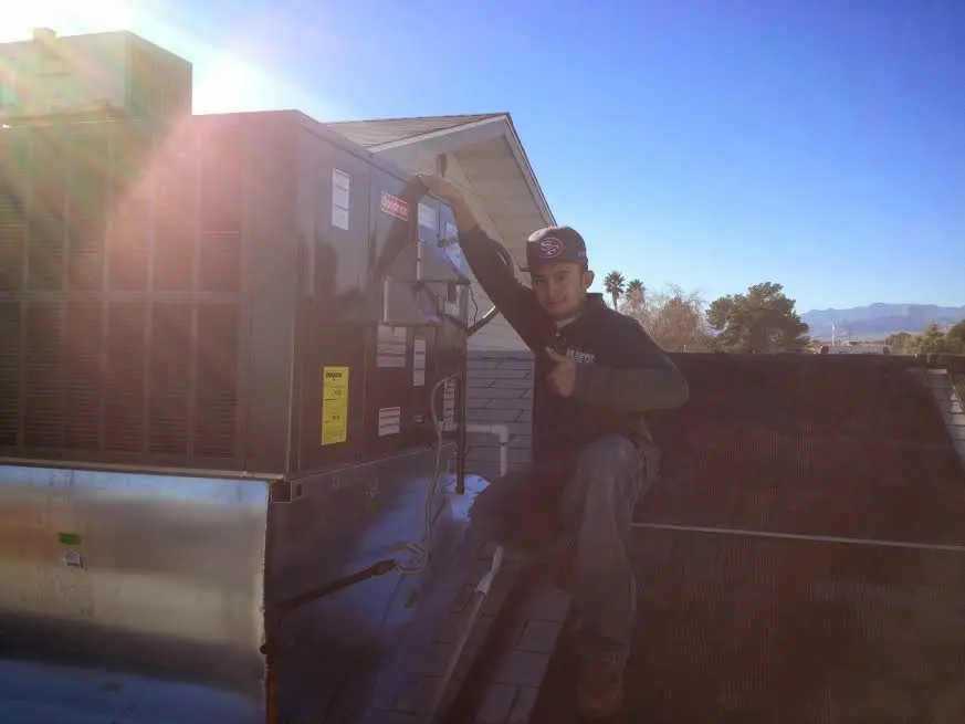 HVAC technician performing Boiler Repair on a rooftop unit in Augusta